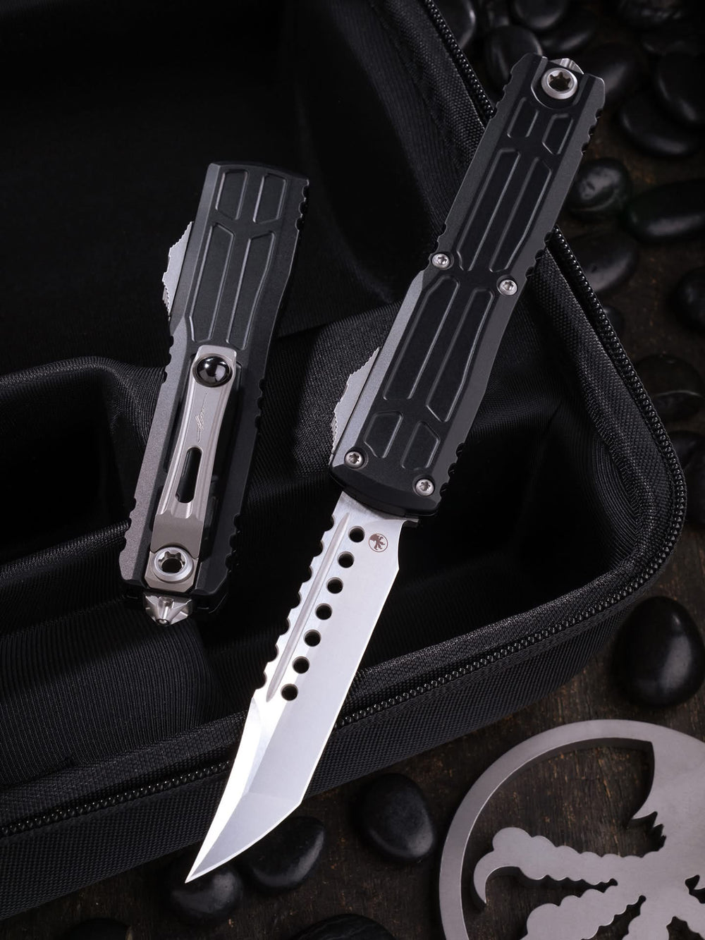 Two folding knives on a black background with a logo in the corner.