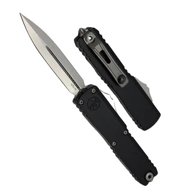 Black folding knife with a silver blade on a light gray background