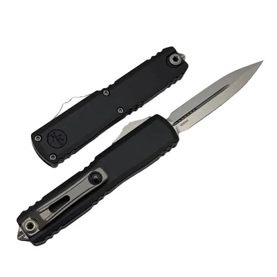 Black folding knife with a silver blade on a light gray background