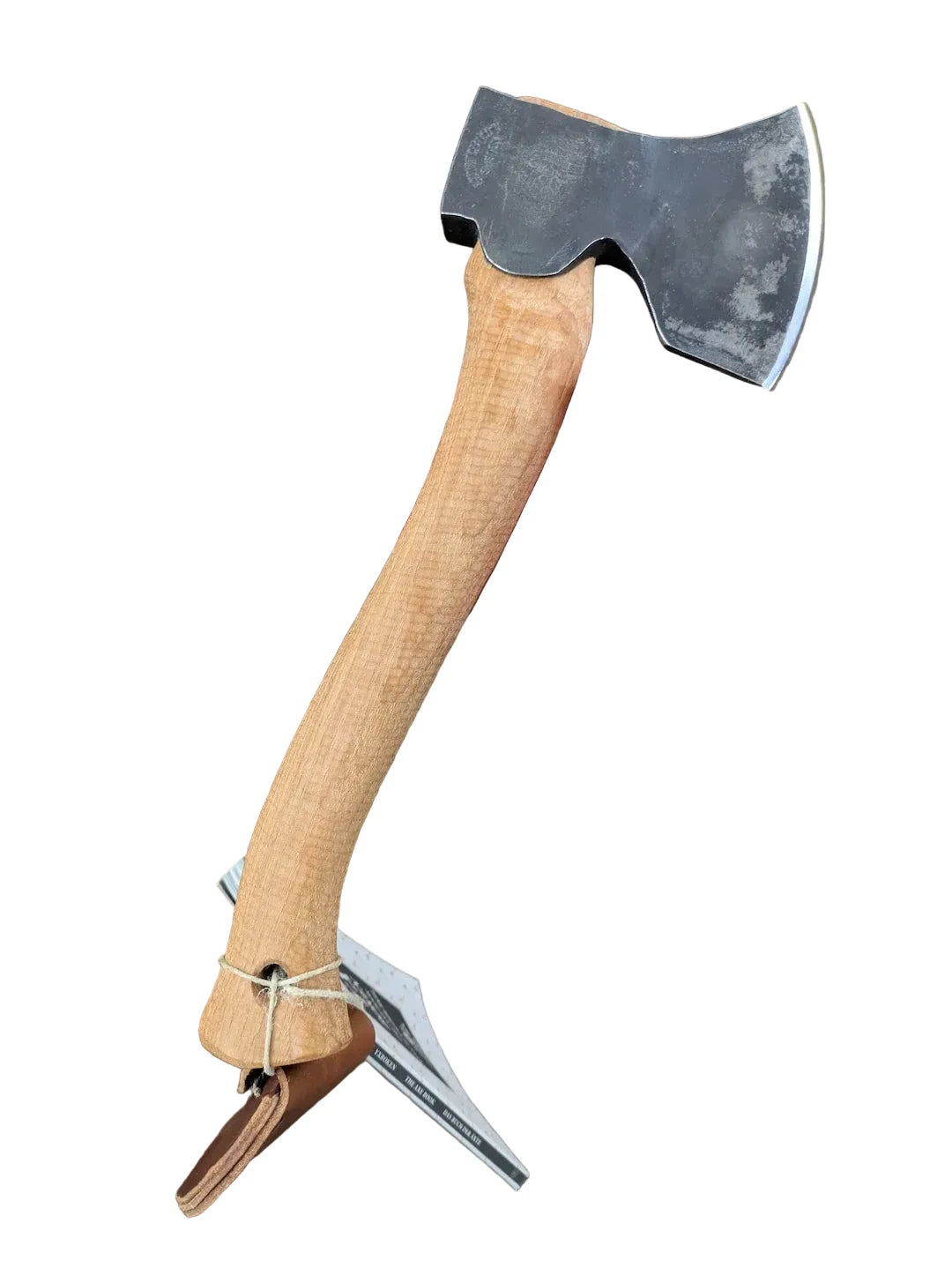 Hand holding a axe with a wooden handle against a brown background