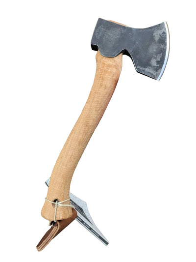 Hand holding a axe with a wooden handle against a brown background