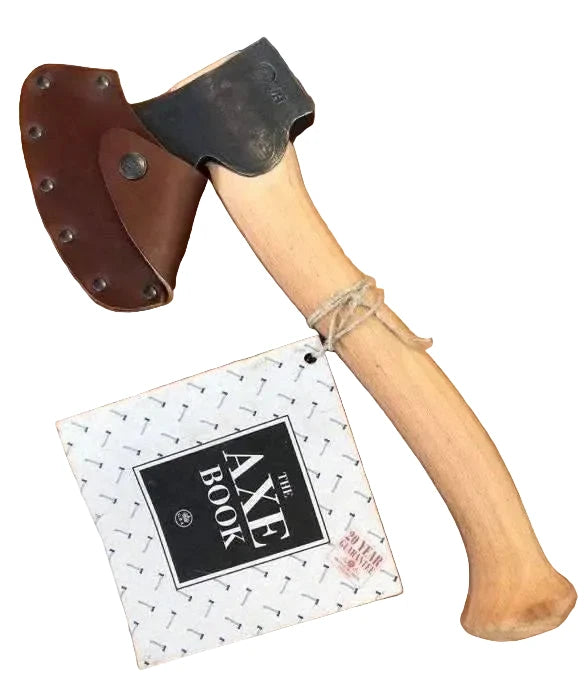 Axes with leather sheathes and 'The Axe Book' on a wooden surface